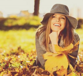 Young woman with perfect smile relaxing in the fall park.