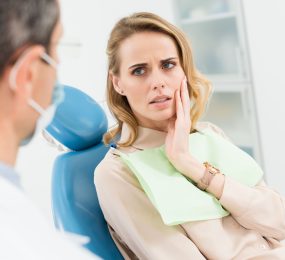 concerned stressed woman in a dental chair talking to a dentist