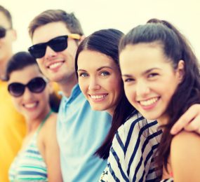 A group of young happily smiling people enjoying their time together on the beach