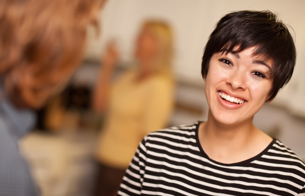 Laughing Young Woman Socializing in a Party Setting.