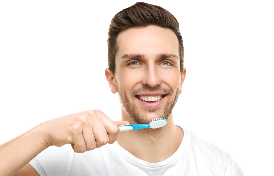 Young handsome man brushing teeth on white background