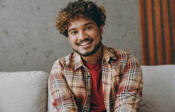 Cheerful Afro-American man with a perfect smile sitting on a sofa