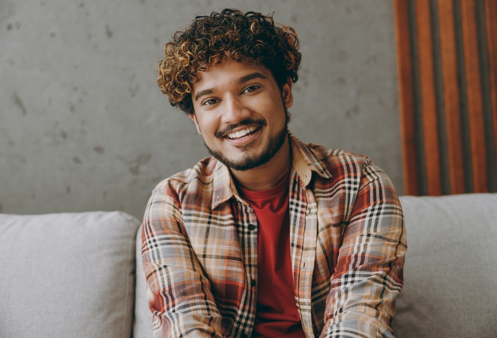 Cheerful Afro-American man with a perfect smile sitting on a sofa