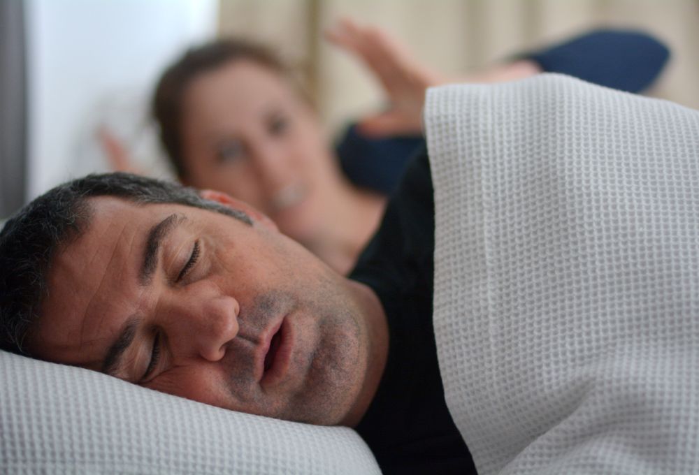 A frustrated woman not able to sleep at night cause of her husband's loud snoring