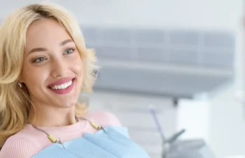 Relaxed blonde woman smiling to her dentist, side view, copy space. Peaceful pretty young lady having conversation with her doctor stomatologist, enjoying modern treatment at new dental clinic