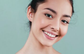Beauty Woman face Portrait. Beautiful model Girl with Perfect Fresh Clean Skin color lips purple red. Healthy teeth smile Youth and Skin Care Concept. I